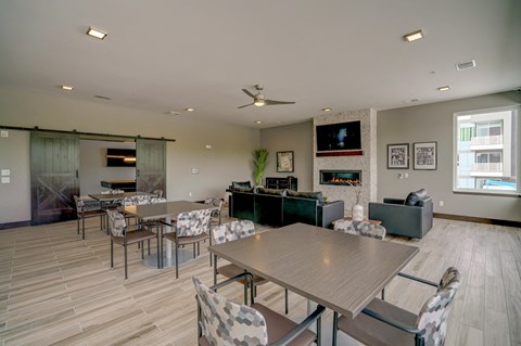 a dining room with tables and chairs and a living room with a television